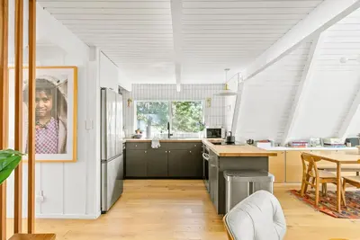a kitchen with white walls and a large window at Luxury A-Frame Retreat in Lake Arrowhead