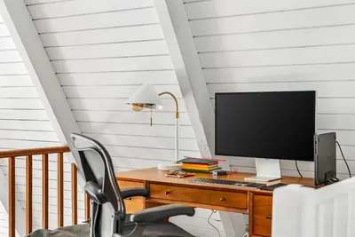 a desk with a computer monitor and a chair at Luxury A-Frame Retreat in Lake Arrowhead