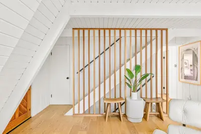 a staircase in a white room with a potted plant at Luxury A-Frame Retreat in Lake Arrowhead