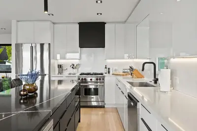 a kitchen with white cabinets and stainless steel appliances at Hollywood Hills 3 Bedroom Views and Jacuzzi in Los Angeles