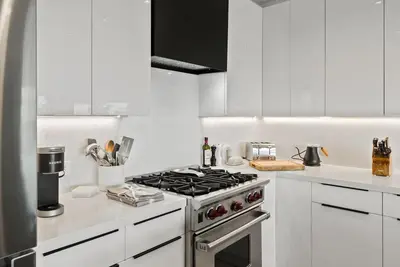 a white kitchen with a stove and white cabinets at Hollywood Hills 3 Bedroom Views and Jacuzzi in Los Angeles