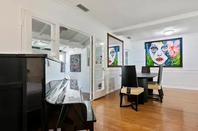 a room with a table and paintings on the walls at Modern piano Los Angeles home by universal studio & Hollywood for 10 in Studio City