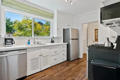 a kitchen with white cabinets and a large window at Modern 4bed 3bath home with piano near Universal Studio & Hollywood for 10 in Studio City