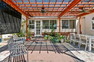 a patio with white chairs and a wooden pergola at Modern 4bed 3bath home with piano near Universal Studio & Hollywood for 10 in Studio City