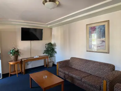 a living room with a couch and a flat screen tv at Fiesta Inn Los Angeles - Bell Gardens in Bell Gardens