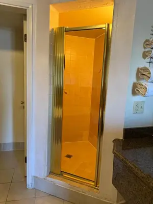a shower with a glass door in a bathroom at Fiesta Inn Los Angeles - Bell Gardens in Bell Gardens