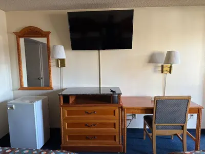 a room with a desk and a television on a wall at Fiesta Inn Los Angeles - Bell Gardens in Bell Gardens