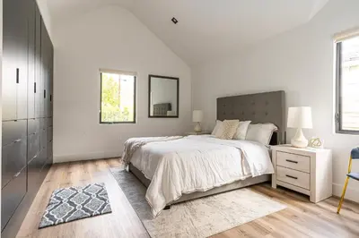 a white bedroom with a large bed and a mirror at Tulum Style in Sherman Oaks in Garnsey