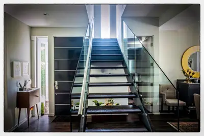 a staircase in a living room with blue stairs at Luxury Living in West Hollywood Modern 3BR Home w Pool & Hot tub in Los Angeles