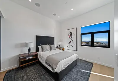 a white bedroom with a bed and a window at Ocean to City Views, Fire Feature, Water falls Dream Oasis in Los Angeles