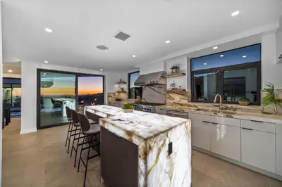 a kitchen with a large island with bar stools at Ocean to City Views, Fire Feature, Water falls Dream Oasis in Los Angeles