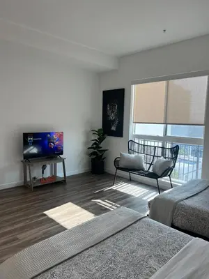a white room with a television and a bed and a chair at The sunset loft apartment FREE parking in Los Angeles