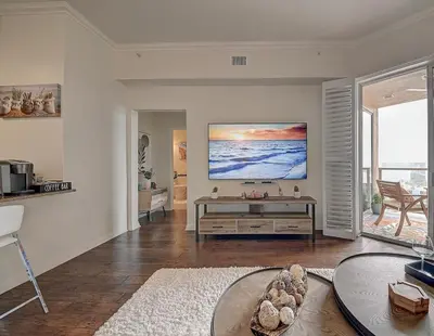 a living room with a table and a tv on the wall at Ocean View Suite by Convention Center & Beach in Long Beach