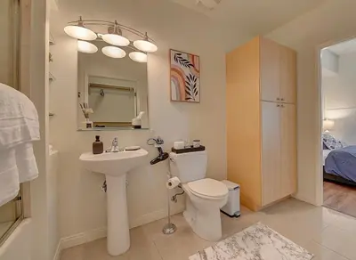 a bathroom with a sink and a toilet and a mirror at Ocean View Suite by Convention Center & Beach in Long Beach