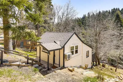 a tiny house in the middle of a forest at Tiny Home with Deck and Mtn Views in Lake Arrowhead! in Lake Arrowhead