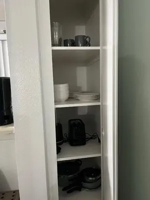 a white pantry with plates and dishes on shelves at Starlight Studio near Sunset in Los Angeles