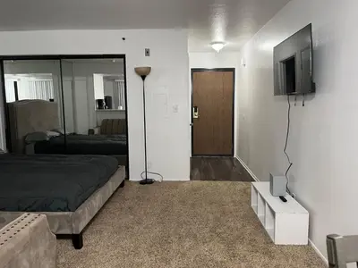 a bedroom with a bed and a television on a wall at Starlight Studio near Sunset in Los Angeles