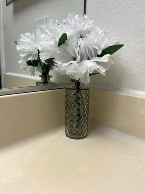 a vase filled with white flowers in front of a mirror at Starlight Studio near Sunset in Los Angeles