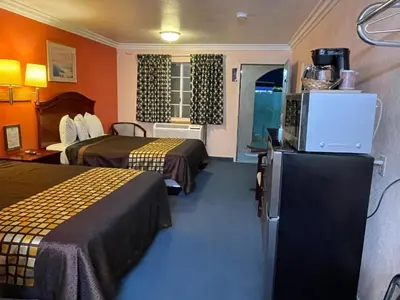 a hotel room with two beds and a television at Aerospace Inn in Mojave