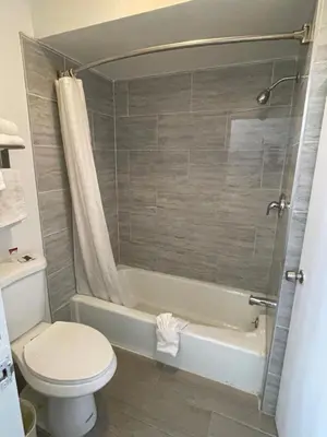 a bathroom with a toilet and a tub and a shower at Aerospace Inn in Mojave