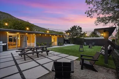 a backyard with picnic tables and chairs at night at Malibu Beach House by Stay Awhile Villas in Malibu