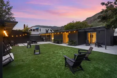 a backyard with chairs and tables and a building at Malibu Beach House by Stay Awhile Villas in Malibu