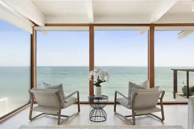 a room with two chairs and a view of the ocean at Malibu Cove Colony Beach by Stay Awhile Villas in Malibu