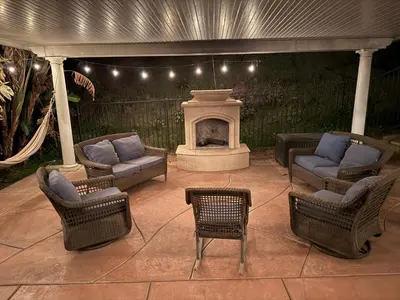 a patio with four chairs and a fireplace at Riverside Views & Pool Retreat in Riverside