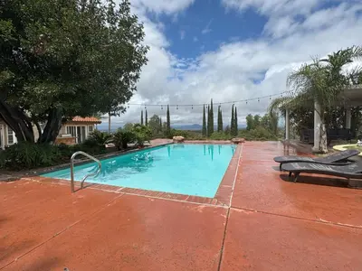 a large swimming pool with a red brick patio at Riverside Views & Pool Retreat in Riverside