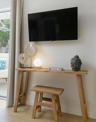 a wooden table with a television on a wall at Outdoor Spaces and Coastal Sanctuary in Summerland