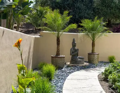 a garden with a statue and palm trees at Private Garden and Tranquil Haven in Summerland