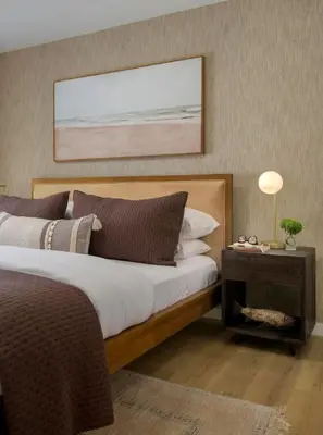 a bedroom with a bed and a table with a lamp at Private Garden and Tranquil Haven in Summerland