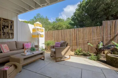 a patio with a couch and chairs and a fence at Private Garden and Tranquil Haven in Summerland