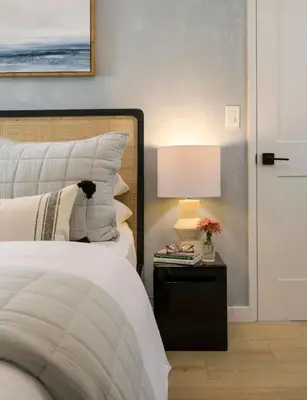 a bedroom with a bed and a table with a lamp at Sunny Getaway and 10 Min to SB in Summerland