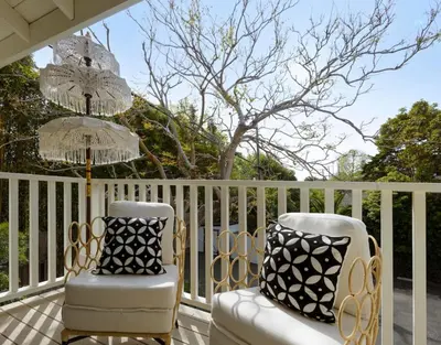 a porch with two chairs and a chandelier at Private Balcony and Coastal Escape in Summerland