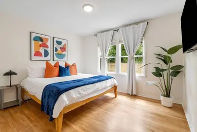 a bedroom with a bed with orange and blue pillows at Vintage Vibes Near Airport Games Sleeps 8 in Long Beach