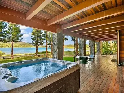 a large jacuzzi tub on a deck with a view of the water at Bear Lake Lodge Lakefront Incredible Lake House Chalet in Big Bear Lake