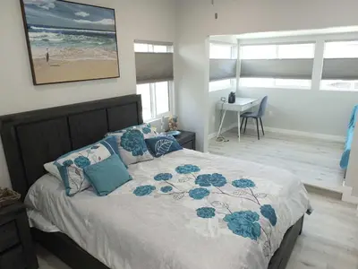 a bedroom with a bed with blue pillows and a desk at Beach & Bay Retreat - Full of Amenities in Long Beach