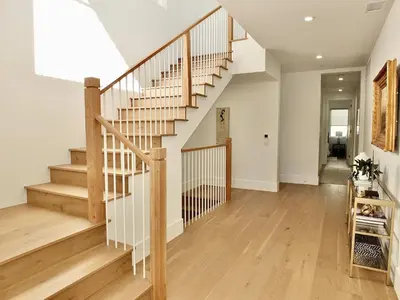 a staircase in a home with white walls and wooden floors at Beach Paradise - Stunning 3-Story in Long Beach in Long Beach
