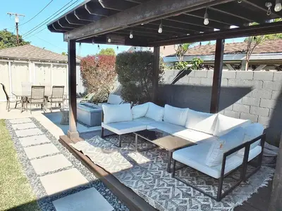a patio with a couch and a table and chairs at Bellflower Breeze - Charming 3 BDR in Long Beach in Long Beach