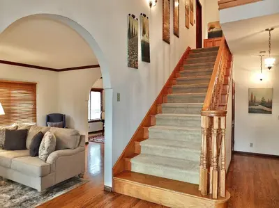a living room with a staircase and a couch at Belmont Heights Retreat - Stunning Gardens in Long Beach