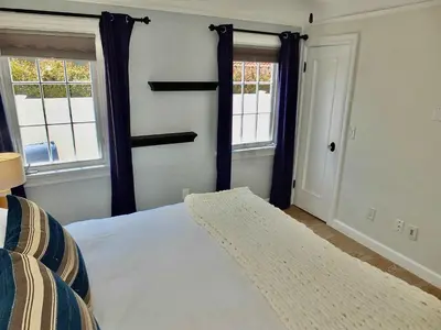 a bedroom with a bed and two windows at Belmont Shore Beach House - Incredible Oceanfront Views in Long Beach