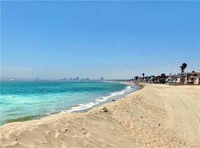 a sandy beach with the ocean and buildings in the background at Steps to Beach & Alamitos Bay on LB Peninsula in Long Beach