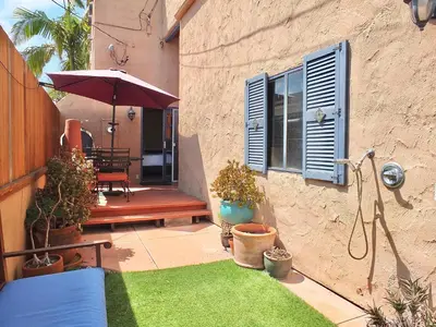 a patio with a table and an umbrella and some plants at La Brisa - One Block from the Beach in Long Beach