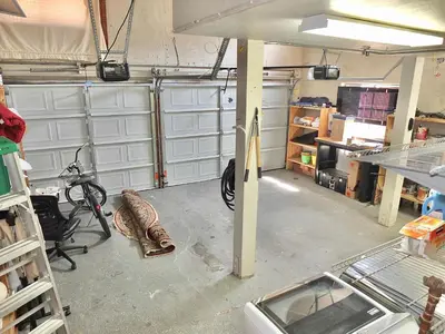 a garage with white garage doors and a room with a bike at La Brisa - One Block from the Beach in Long Beach