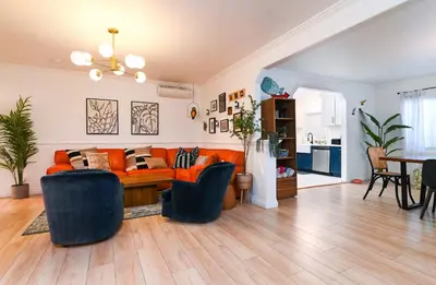 a living room with an orange couch and chairs at Immaculate 3BDR Bungalow - 5-Min Walk to Beach in Long Beach