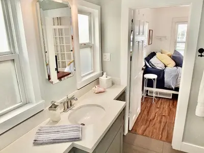a bathroom with a sink and a bedroom with a bed at Park Avenue Beach Paradise - Chic & Secluded 4 BDR in Long Beach