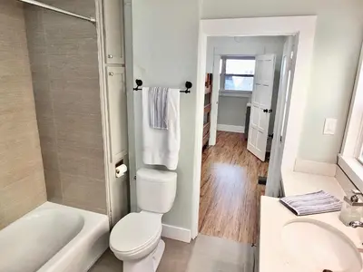 a bathroom with a toilet and a tub and a sink at Park Avenue Beach Paradise - Chic & Secluded 4 BDR in Long Beach