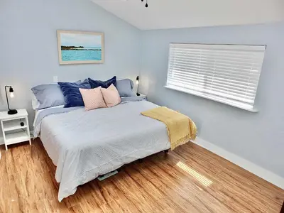 a bedroom with a bed with blue walls and a window at Park Avenue Beach Paradise - Chic & Secluded 4 BDR in Long Beach