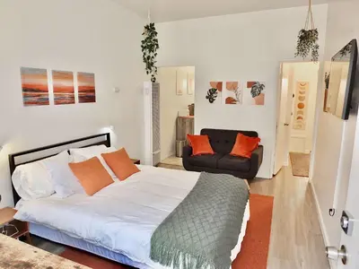 a bedroom with a bed and a couch in it at Sand Sun & Second - Charming Studio within Walking Distance to Beach in Long Beach